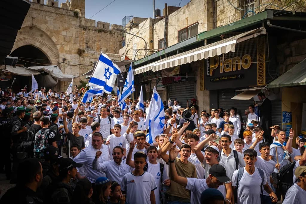 A crowd of men in white shirts with Israeli flags