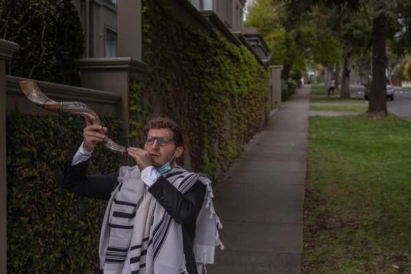 Rabbi Gabi Kaltmann blows the shofar on a Melbourne street corner during Covid lockdown (Asanka Brendon Ratnayake/The Guardian)
