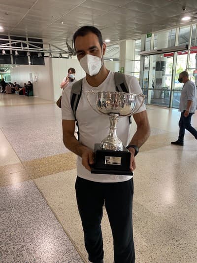 Karatsev's fitness coach Luis Lopes at Melbourne airport with the Sydney Classic trophy (Michael Visontay)