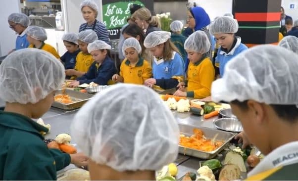 Children participate in a Together for Humanity program, cooking food for the needy