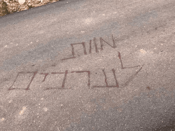 Graffiti reading "Death to Arabs" on the road leading up to the area of the construction site last month (UCI)