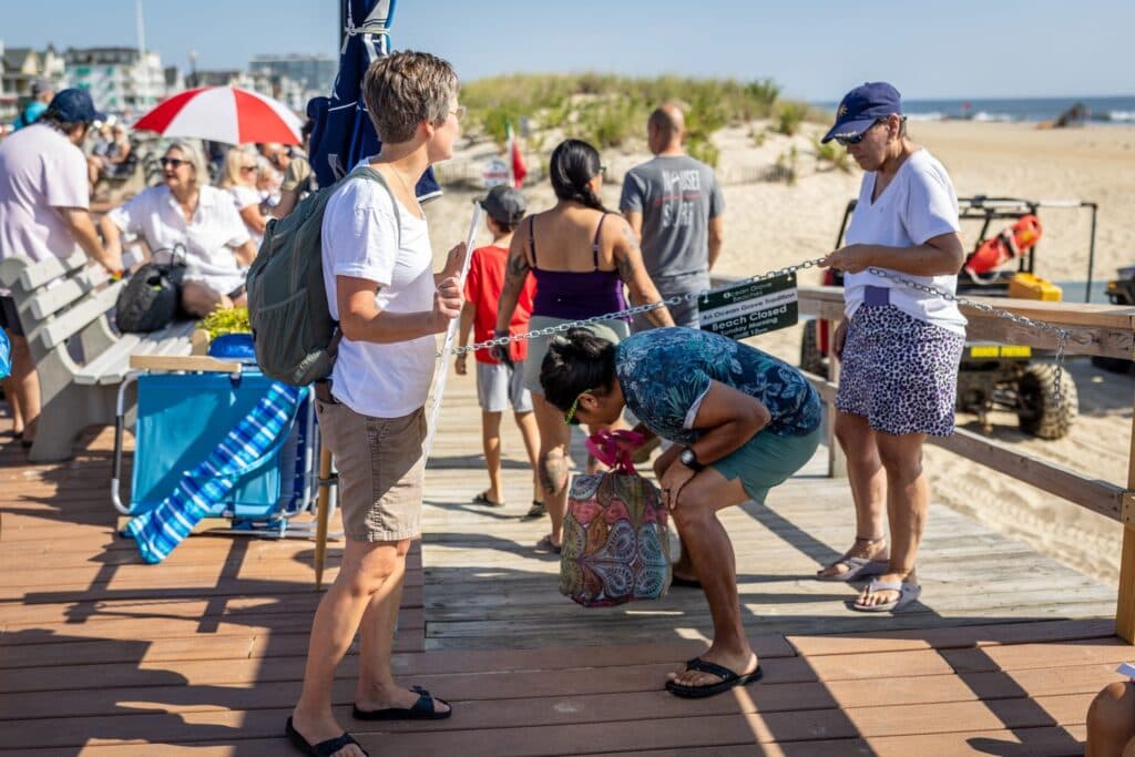 Women entering the beach in Ocean Grove on a recent Sunday morning, defying the sign prohibiting entry before noon (Emil Salman)