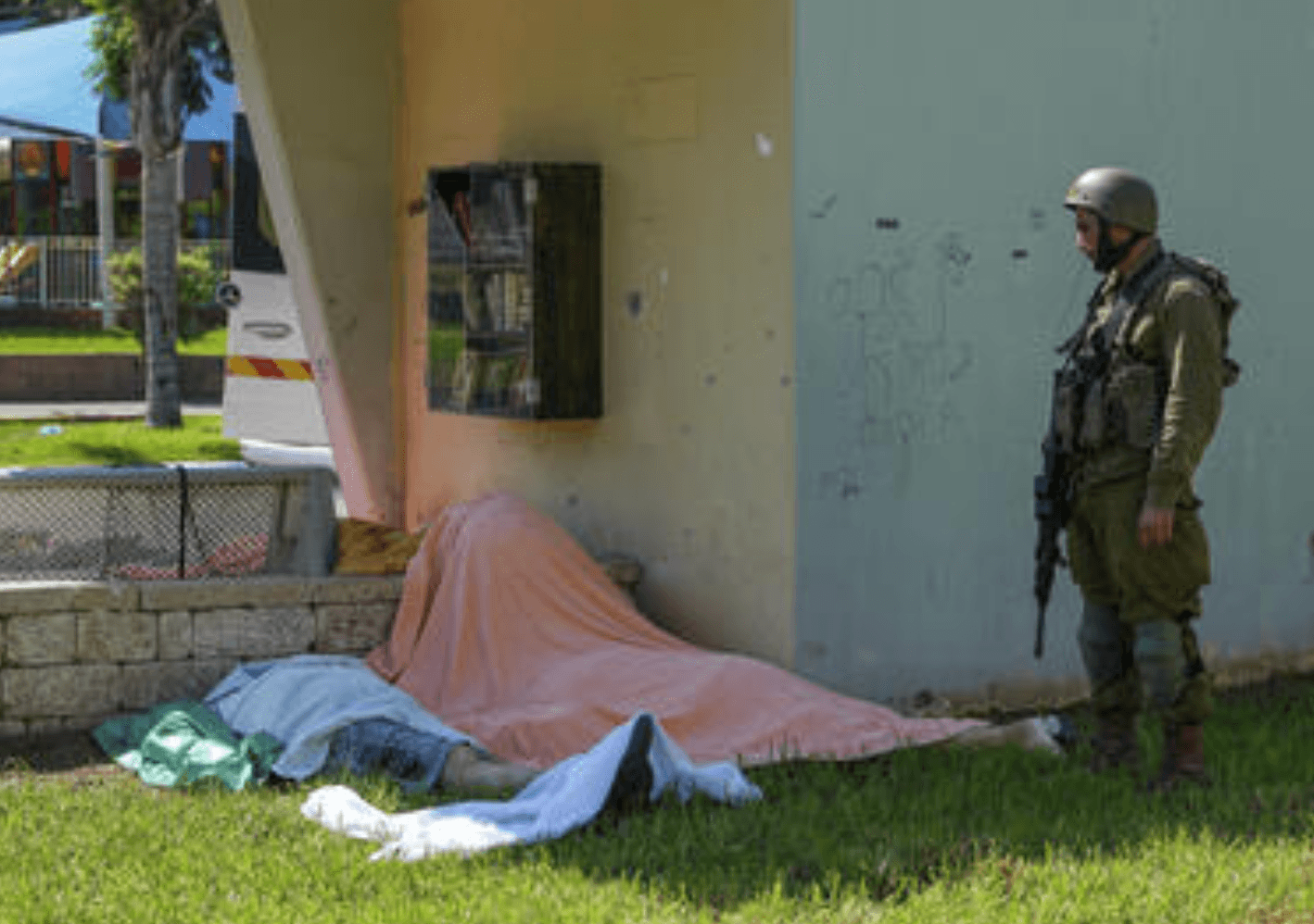An Israeli soldier stands by the bodies of Israelis killed by Palestinian armed militants who entered from the Gaza strip