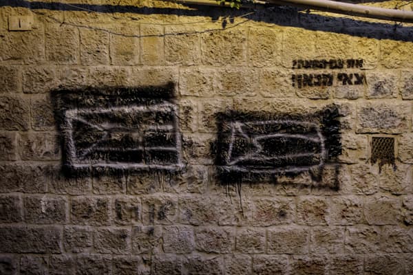 Palestinian flags drawn on the walls of Mea Shearim, covered in black paint