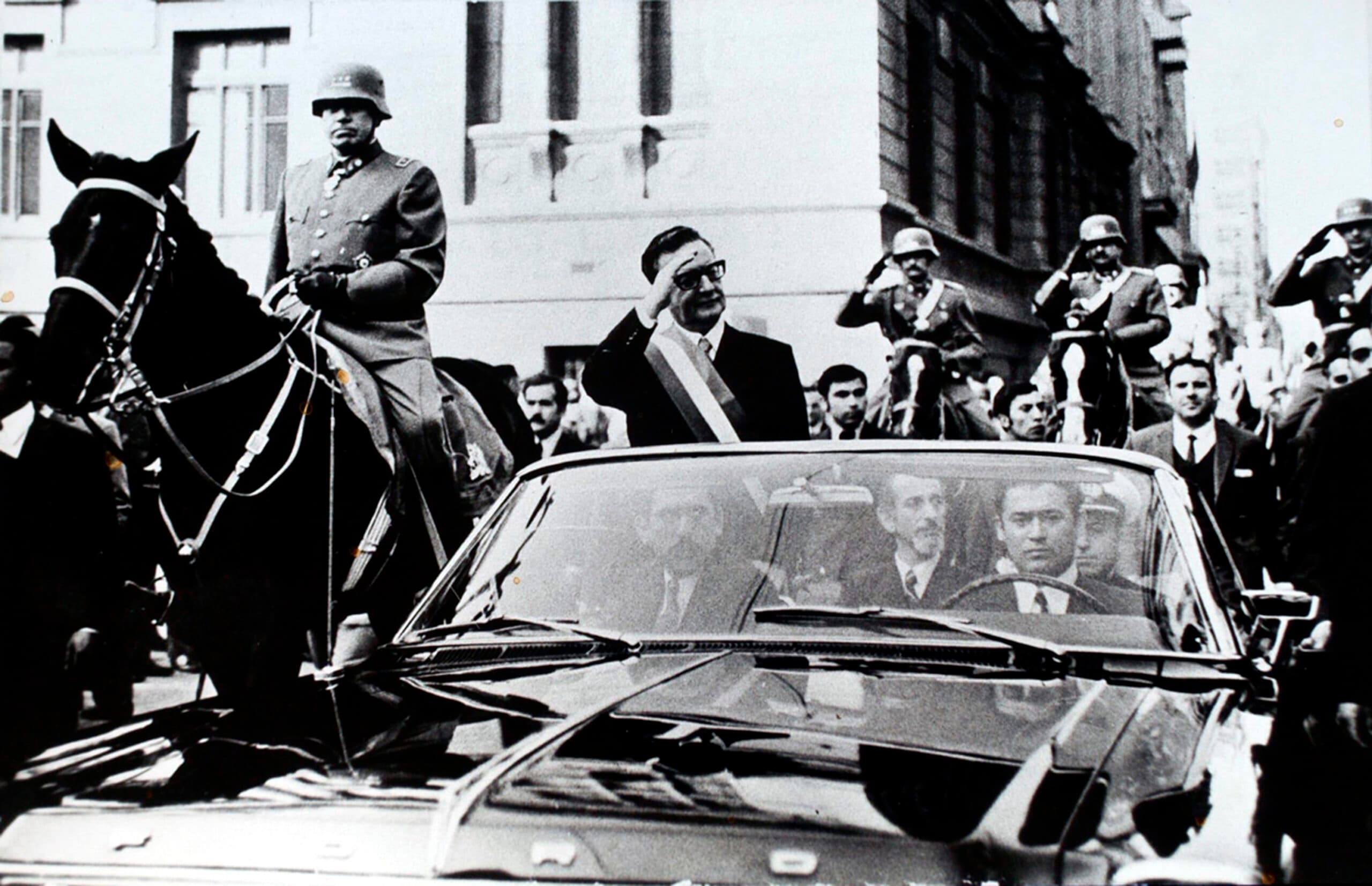 Man standing in a car saluting
