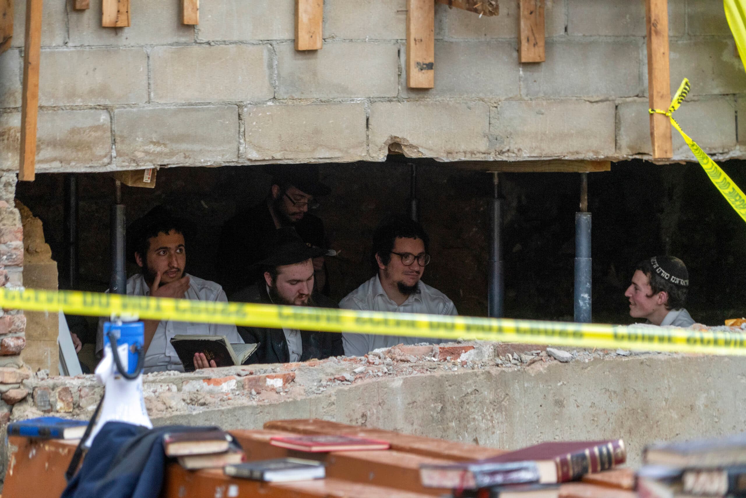 Men behind a gap in a brick wall