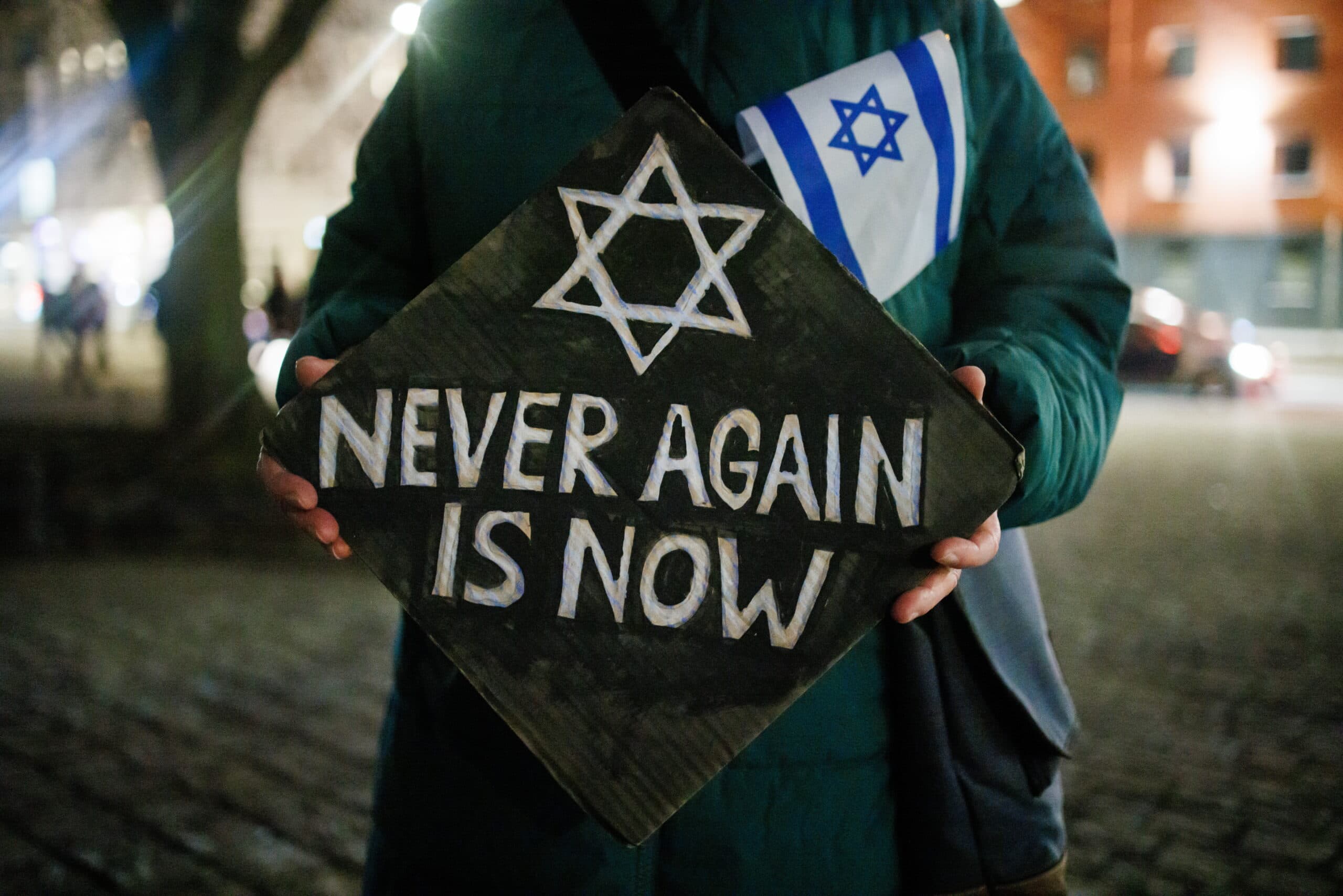 Placard reading 'Never again is now'
