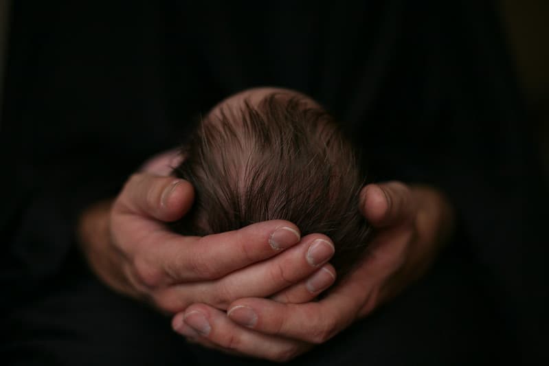 Baby head in adult hands