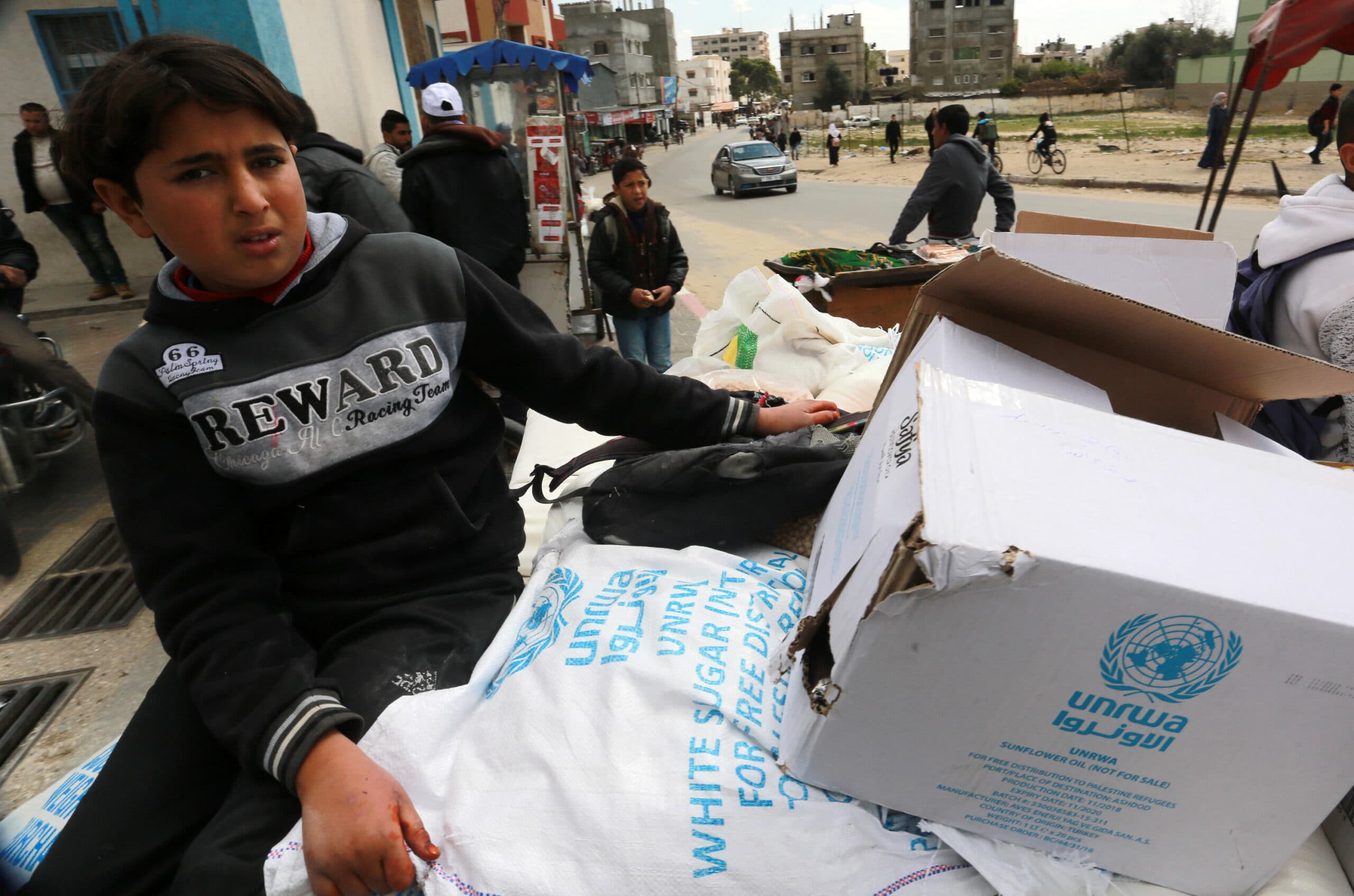 A boy with a box with the UNWRA logo