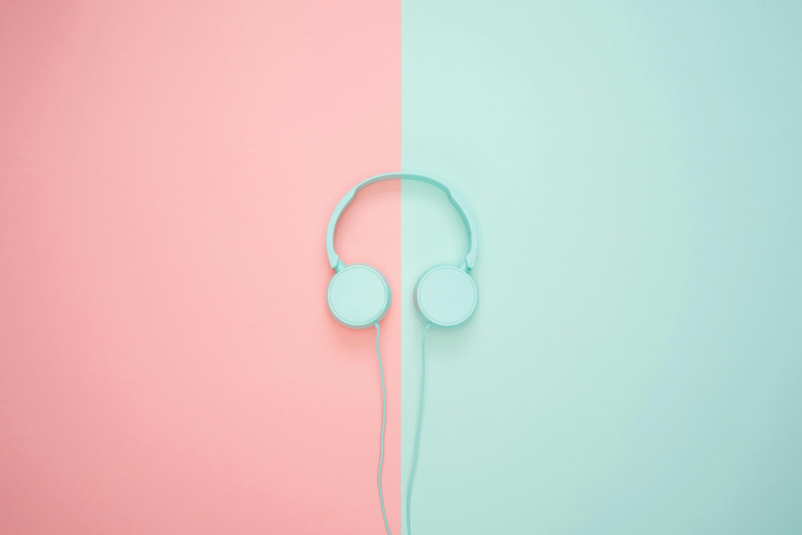 Light blue headphones on pink and blue background symbolising podcasts about Israel.