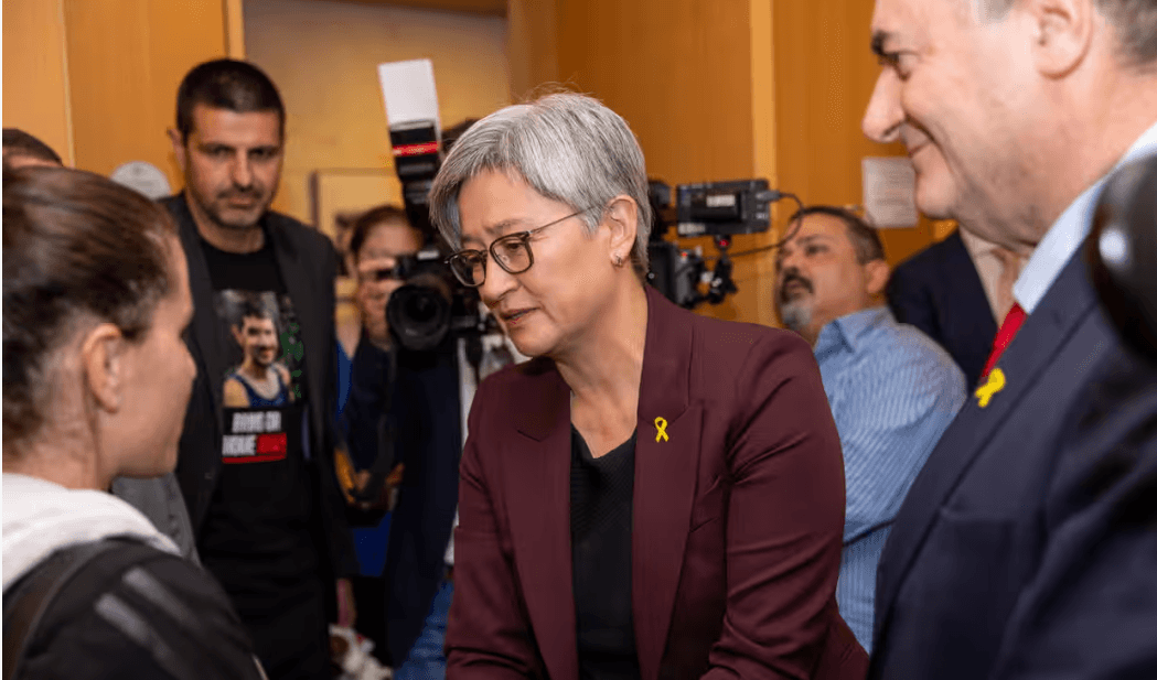 Grey haired woman with glasses talking to a young woman