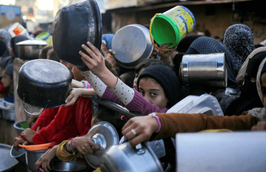 A crowd of children with empty dishes