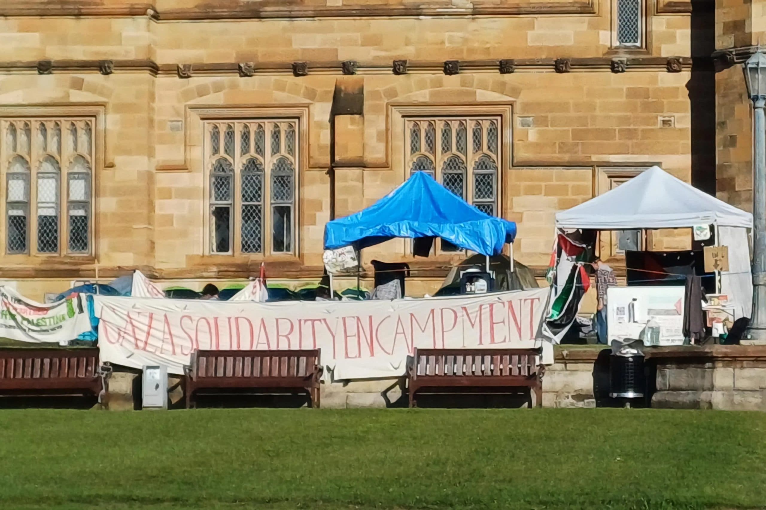 protest banner reading Gaza solidarity in front of university building