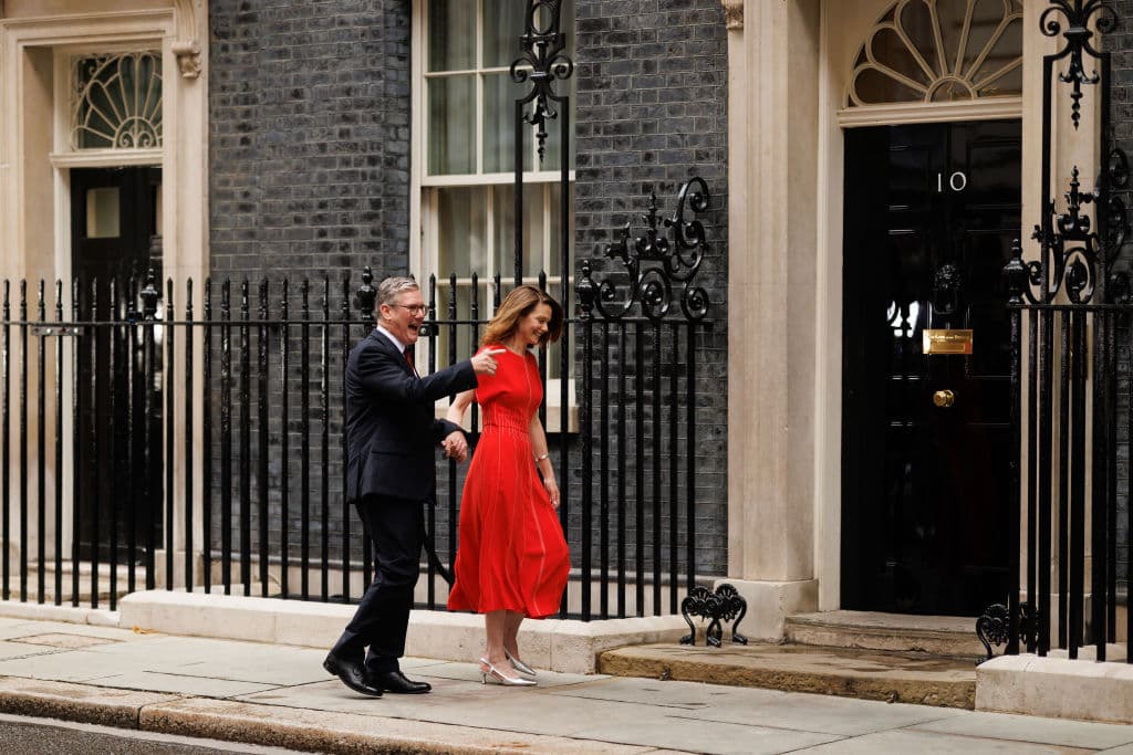 Man in dark suit and woman in red dress at 10 Downing Street