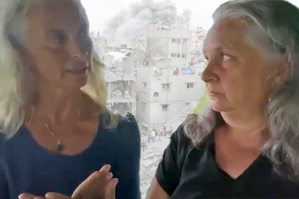Two women with background of devastated Gaza city