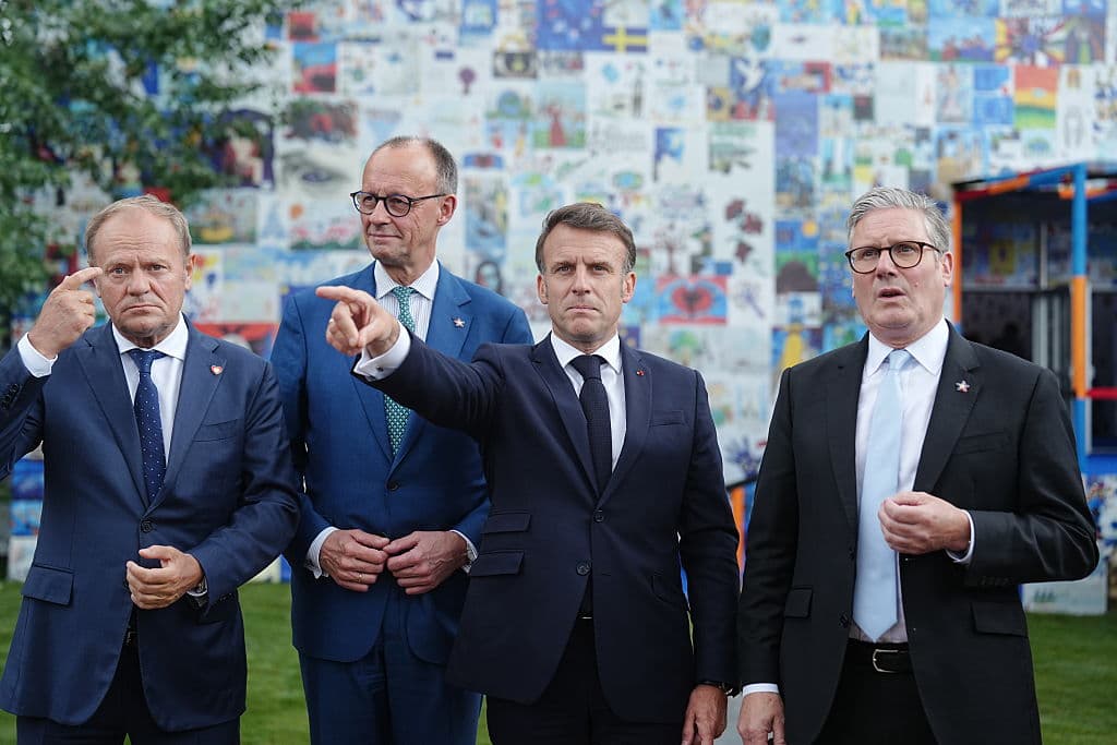 Four men in suits, one pointing forward