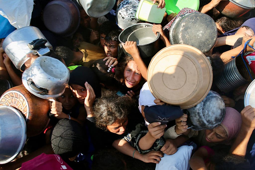 Palestinian children shove to receive a meal at a charity kitchen in the Mawasi area of Khan Yunis in the southern Gaza Strip on July 22, 2025.