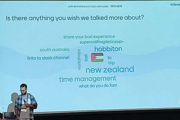 Kovi Rose watches as unprofessional comments and Palestinian flag emojis are projected onto a theatre screen behind him as part of an interactive survey (Image: supplied).