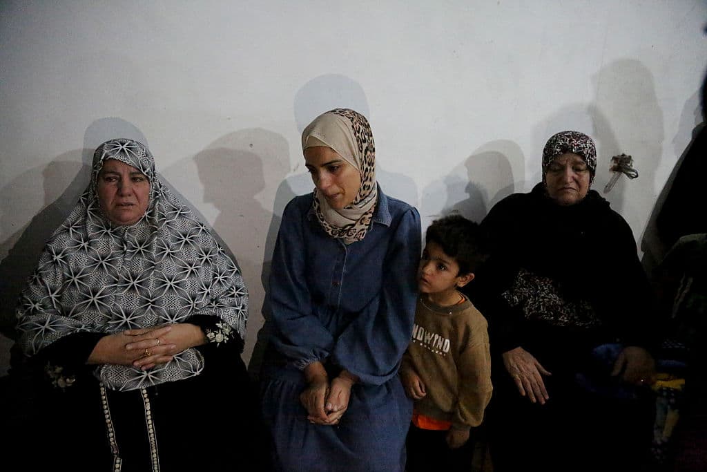 The mother of 10-year-old Mohammed Bahjat Al-Hallaq sits surrounded by relatives in the family home in the village of Al-Rihiyah, south of Hebron, on October 16, 2025, after her son was killed by the Israeli army, according to local sources.