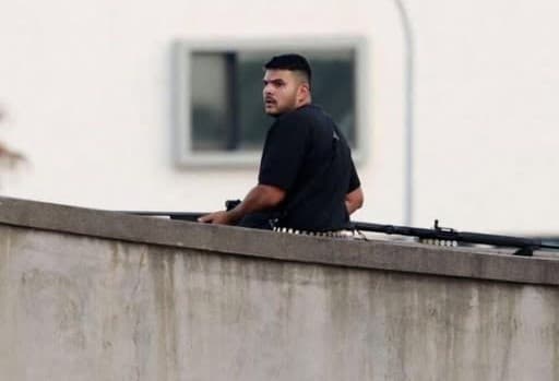 Naveed Akram Bondi attacker seated on a wall overlooking the attack