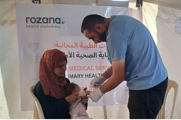 A healthcare worker examines a baby at the Rozana-Anera clinic in Gaza (Rozana)