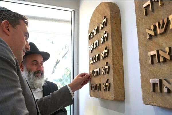 Joshua Lewis inserts missing letters into Ten Commandments