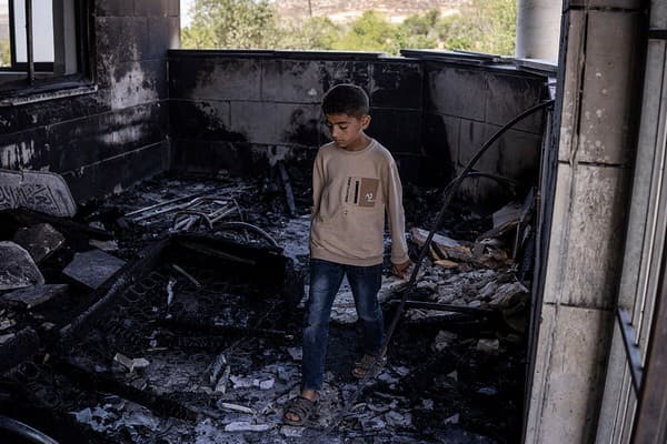 Palestinian boy in a mosque allegedly burned by Israeli settlers in Qusra, south of Nablus, on July 26, 2026 (John Wessels/AFP via Getty)