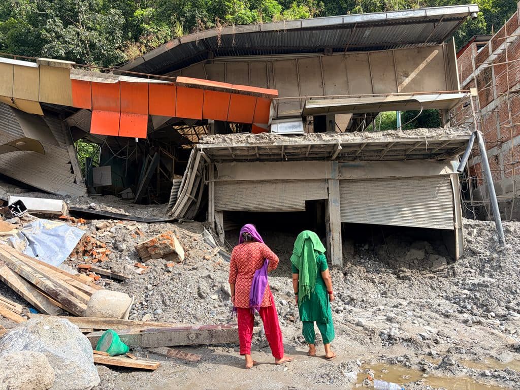 Locals survey a ruined house