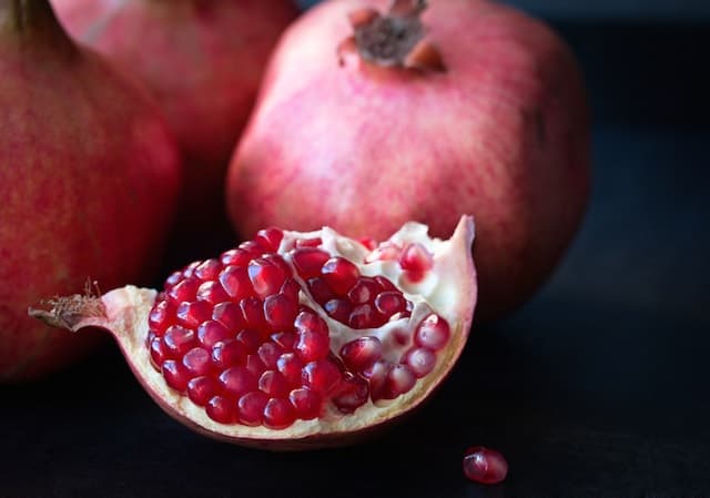 Some red pomegranates on black slate plate