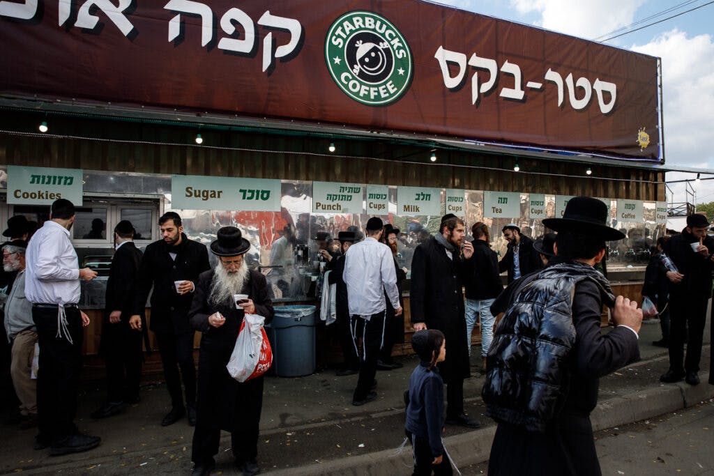 A Starbucks outlet features a Hasid on the logo. The store provides free coffee, tea, milk and petel (fruit punch) to pilgrims.