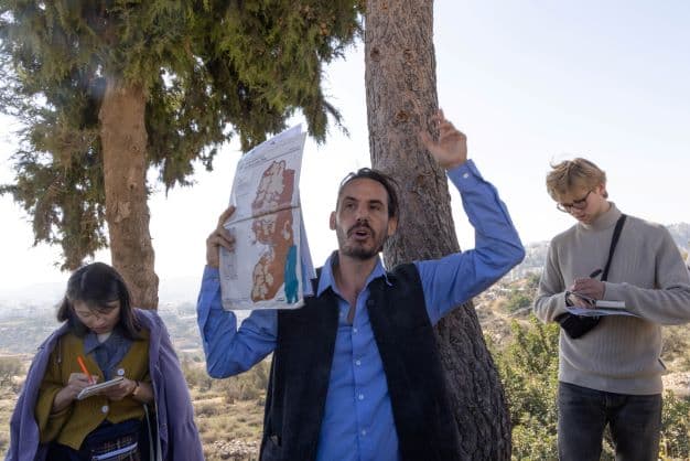 Yaniv Mazor explains the political geography of East Jerusalem to a tour group (Deborah Stone)