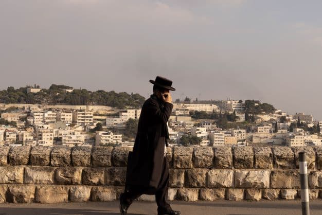 A Haredi Israeli walks along the border between West and East Jerusalem (Deborah Stone)