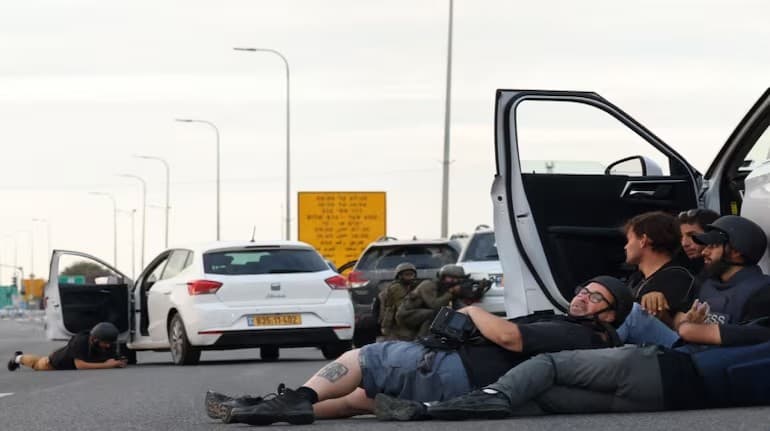 Journalists take cover as Israeli soldiers prepare to fire (AFP)