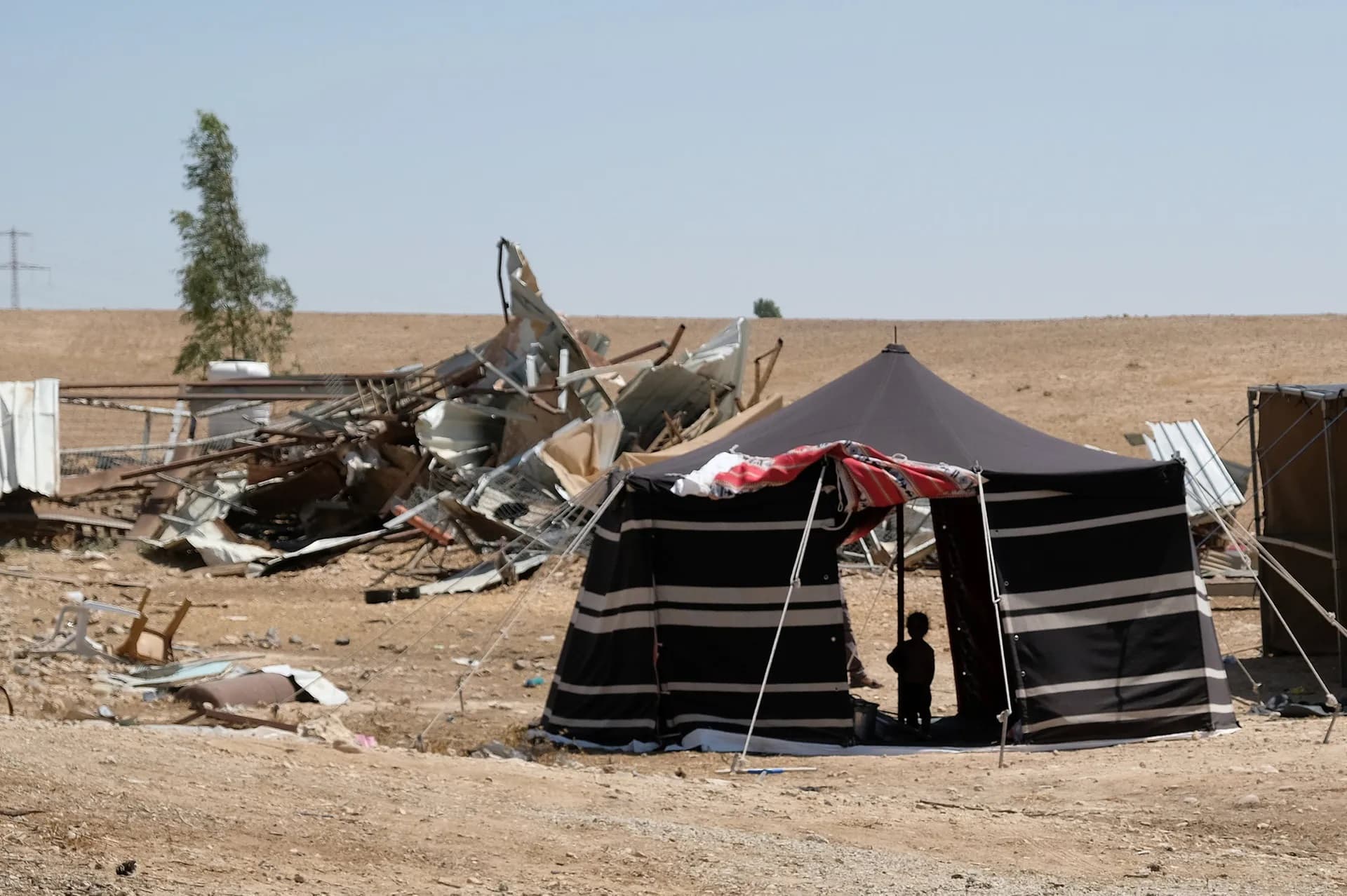 Bedouin tent in the desert with a child in the entrance.