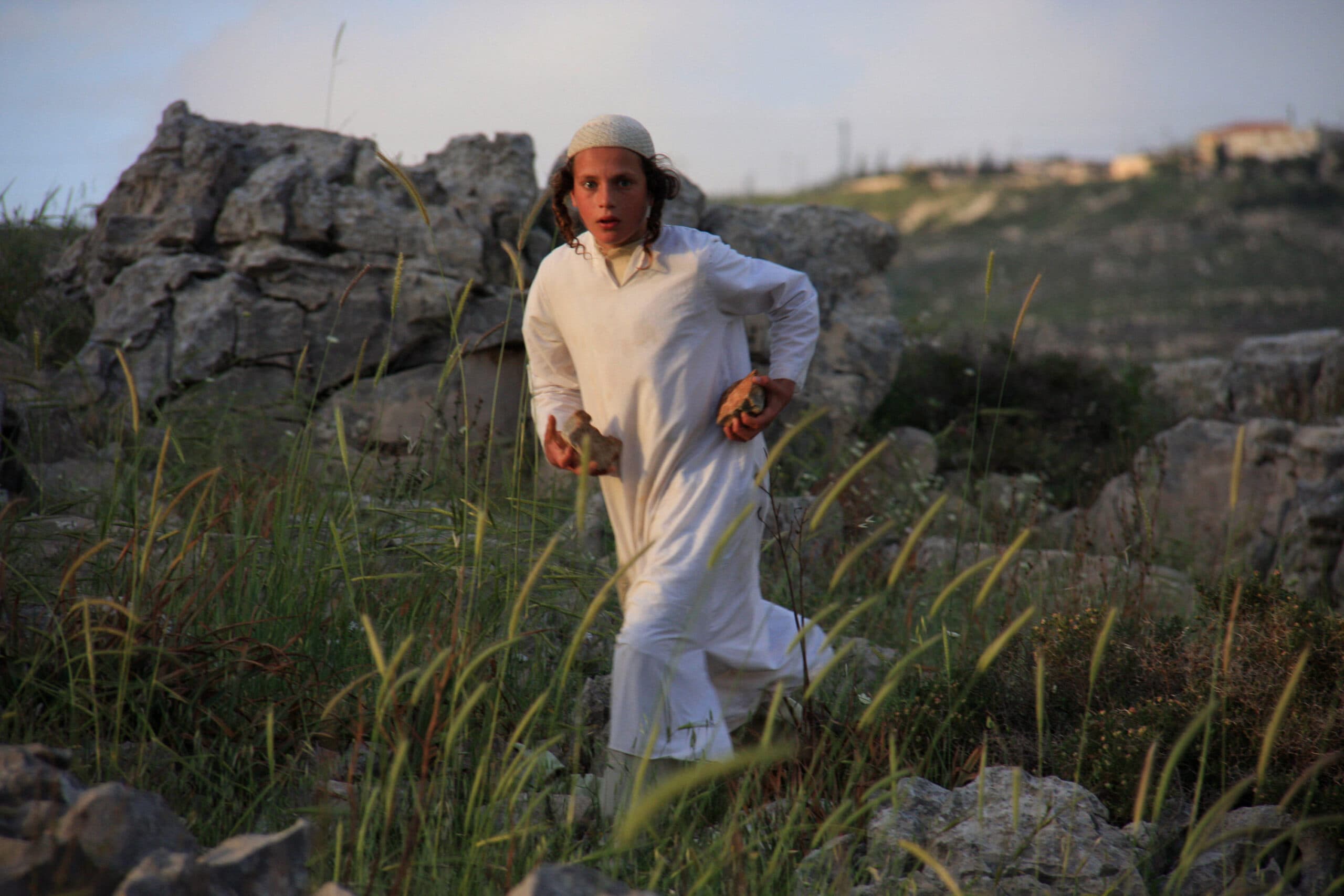 Boy running with stones in his hand