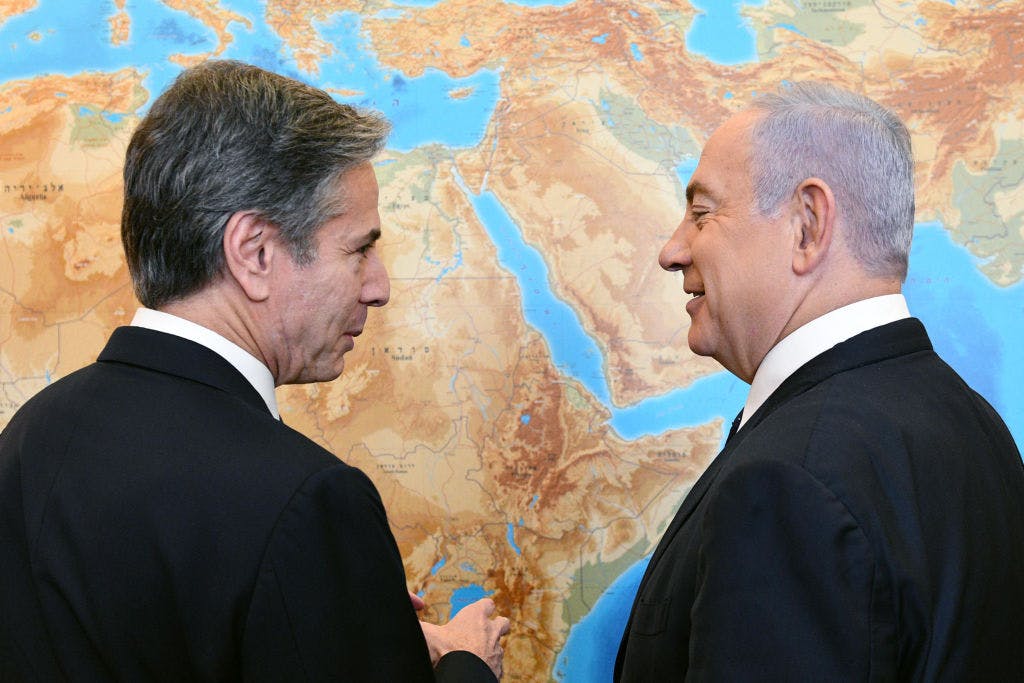 Two men in front of a map of the Middle East