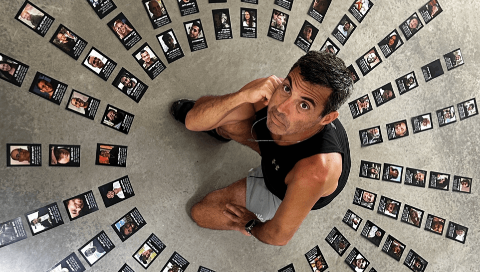 Man surrounded by cards with faces and names on them