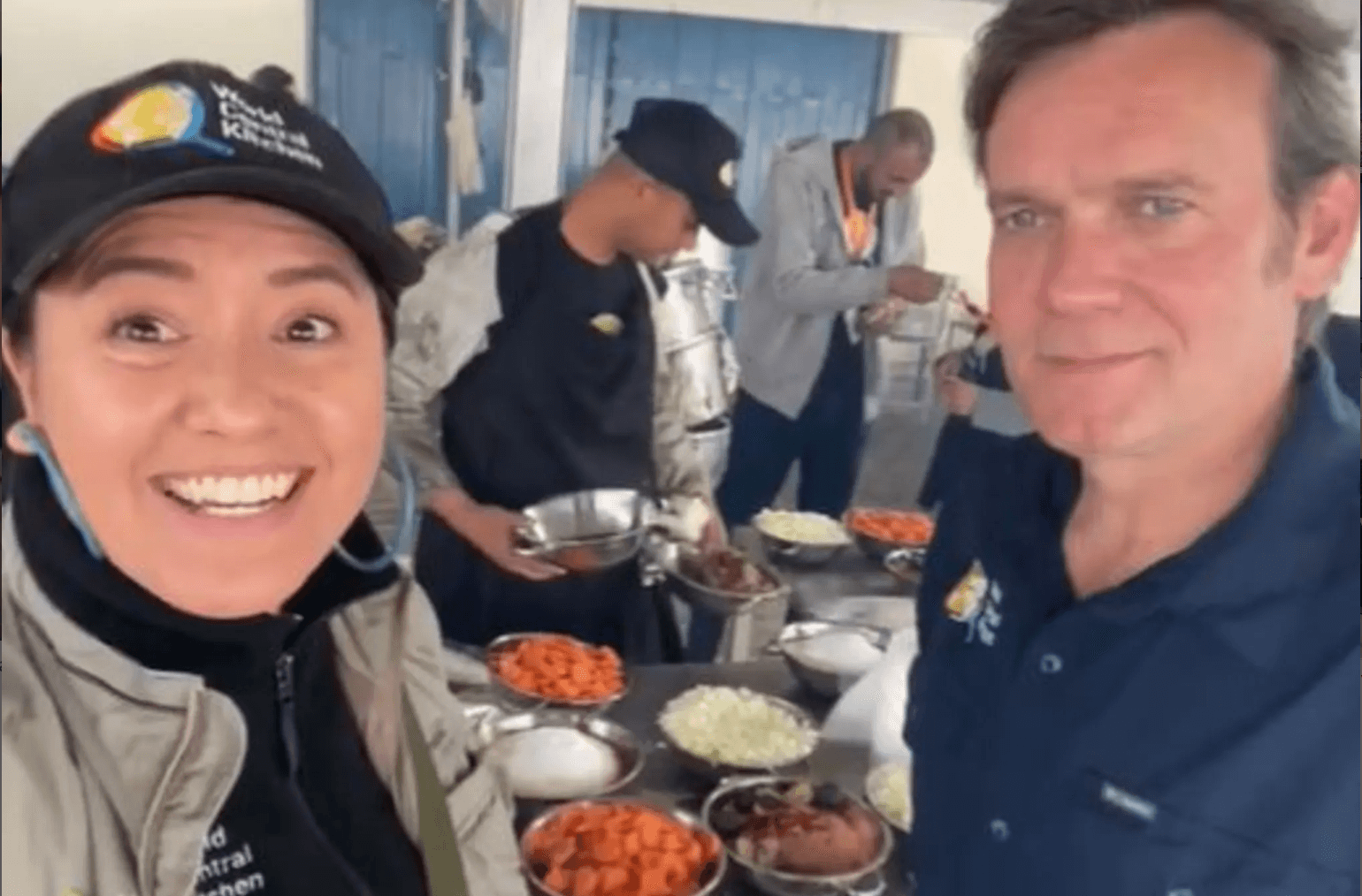 Woman and man in front of people serving food