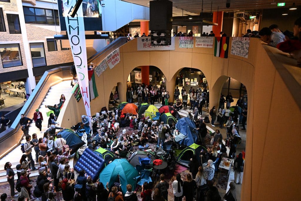Pro-Palestine protesters gather inside Melbourne University's Arts West building on 15 May 2024 to demand the institution severs ties with Israel (Image: AAP Image/James Ross).