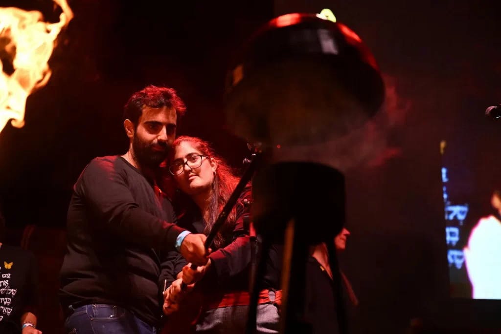 Doron and Shir Shabtai, from Sderot, extinguish a torch at the alternative Independence Day ceremony (Image: Rami Shllush).