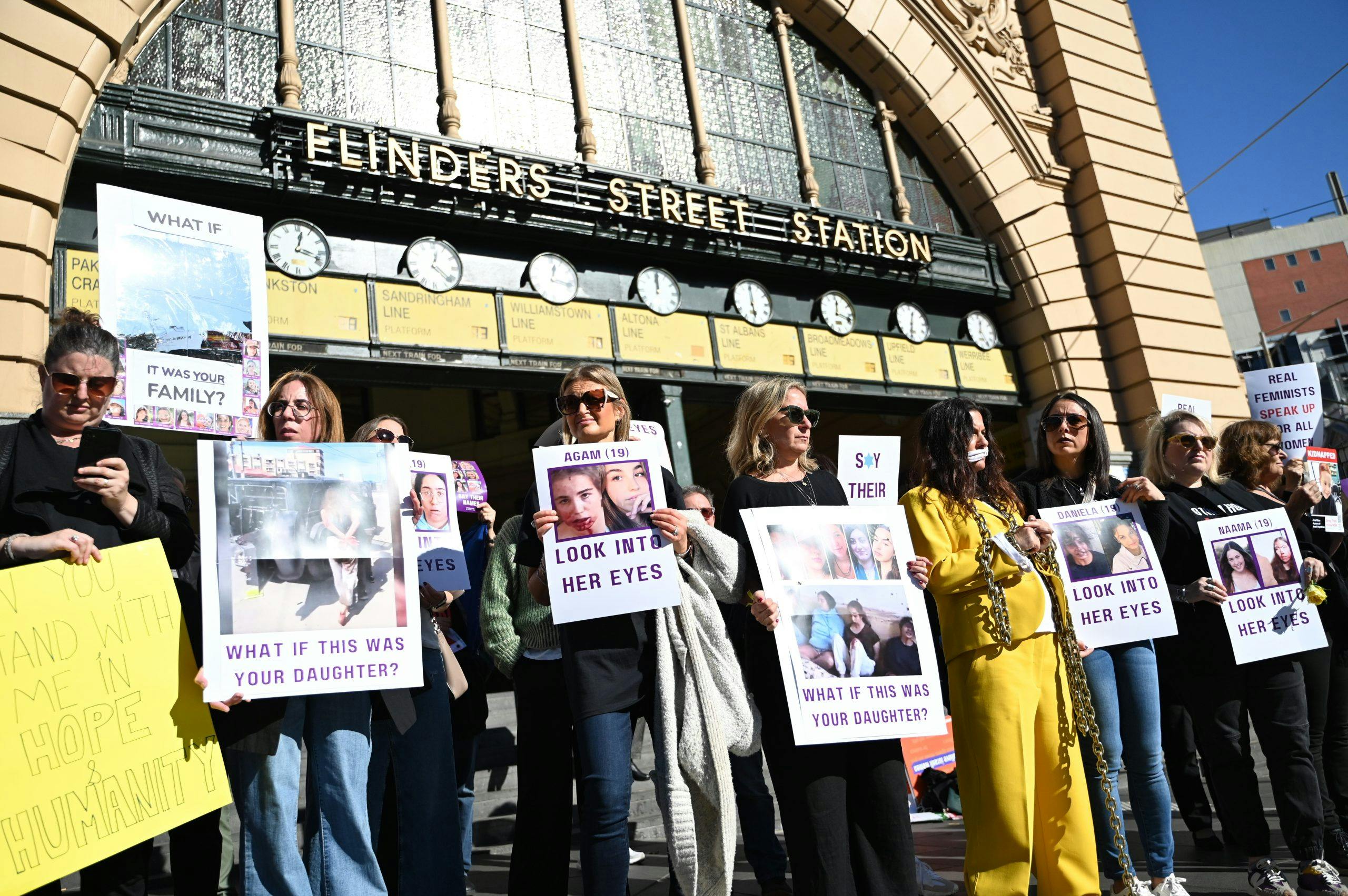 Women protesting on flinders street station steps about sexual crimes committed in Israel on October 7.