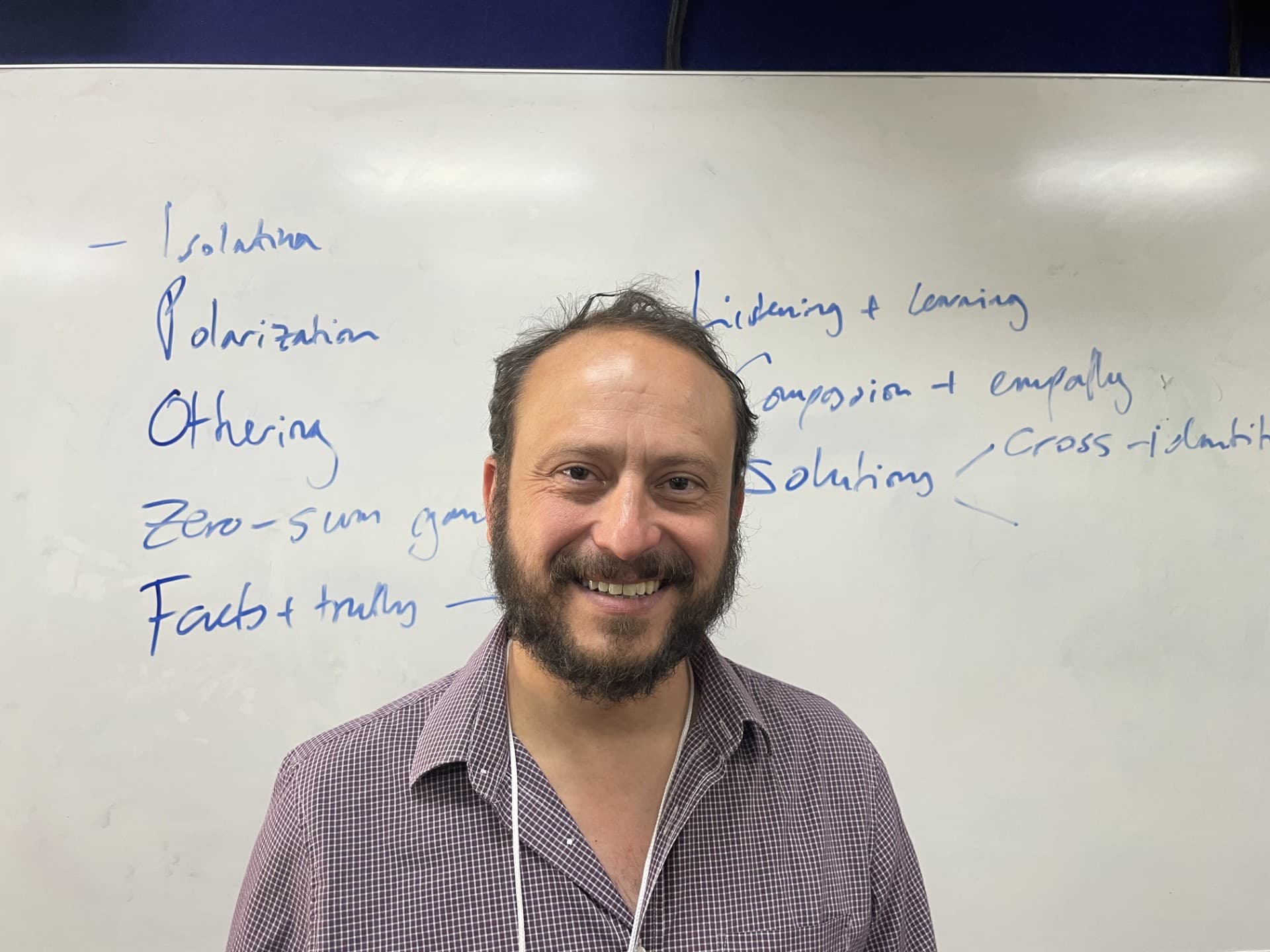 Man in front of a whiteboard with writing.