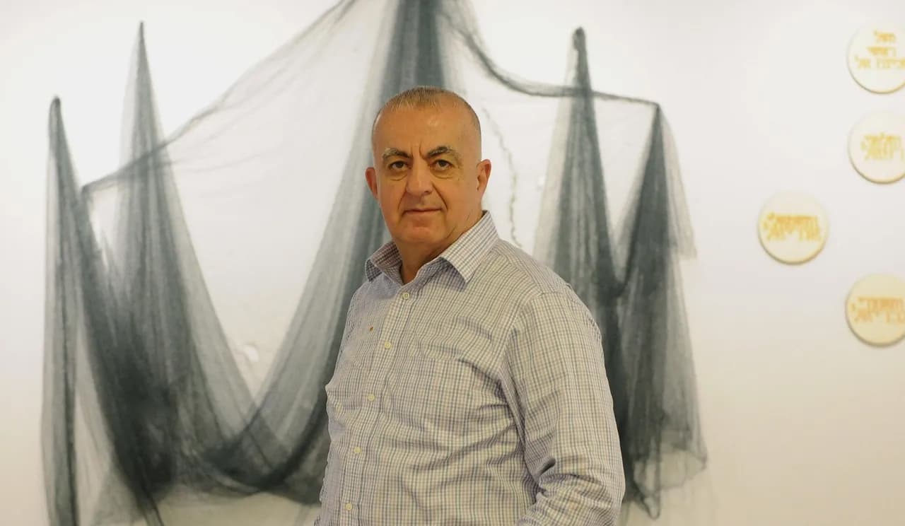 Man in front of hanging net exhibit