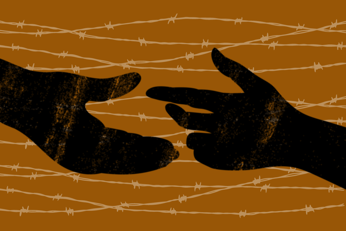 Two hands reaching for each other against a backdrop of barbed wire