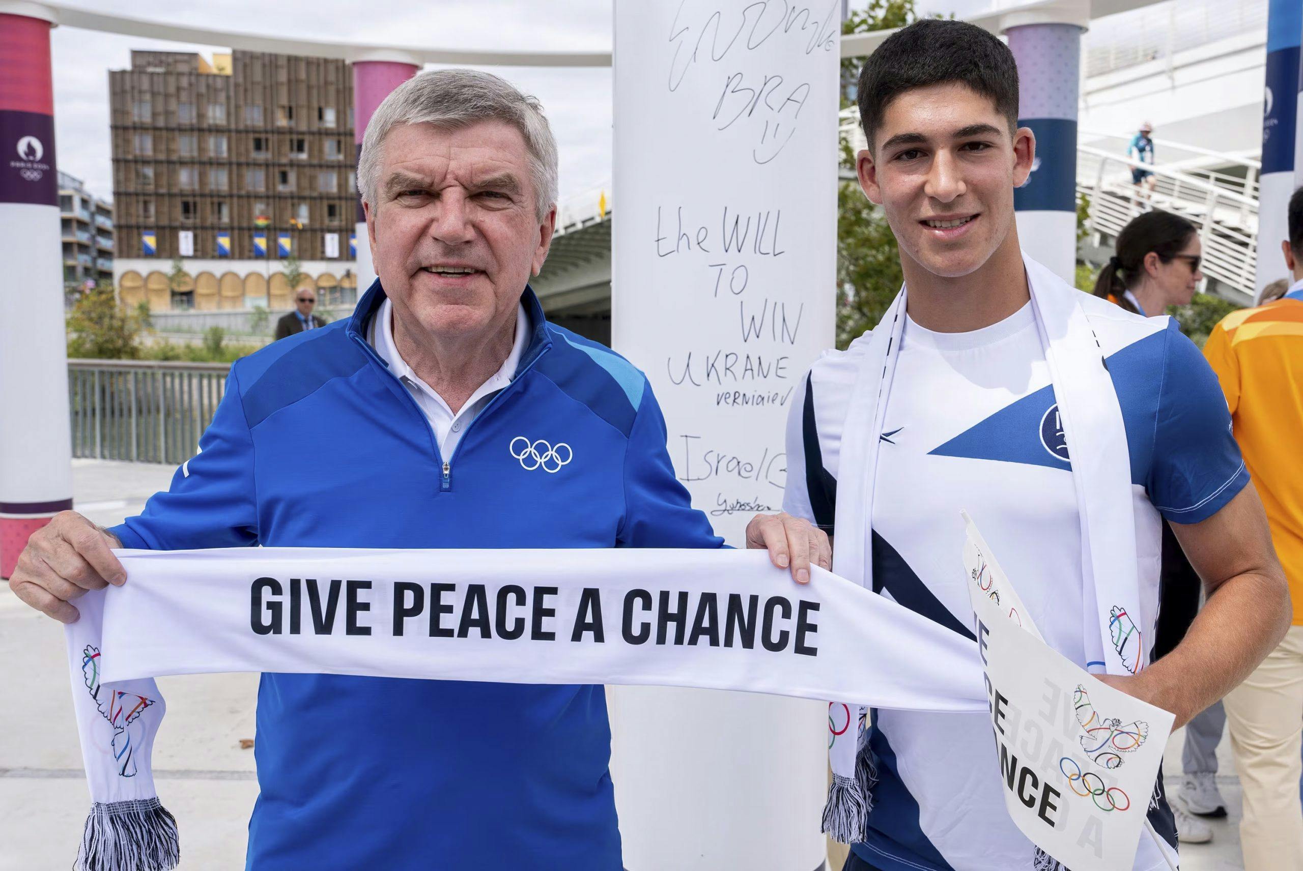 Two men with a banner saying 'Give peace a chance'