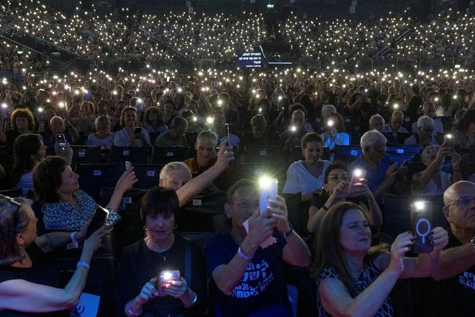 Thousands of people holding lights in the dark