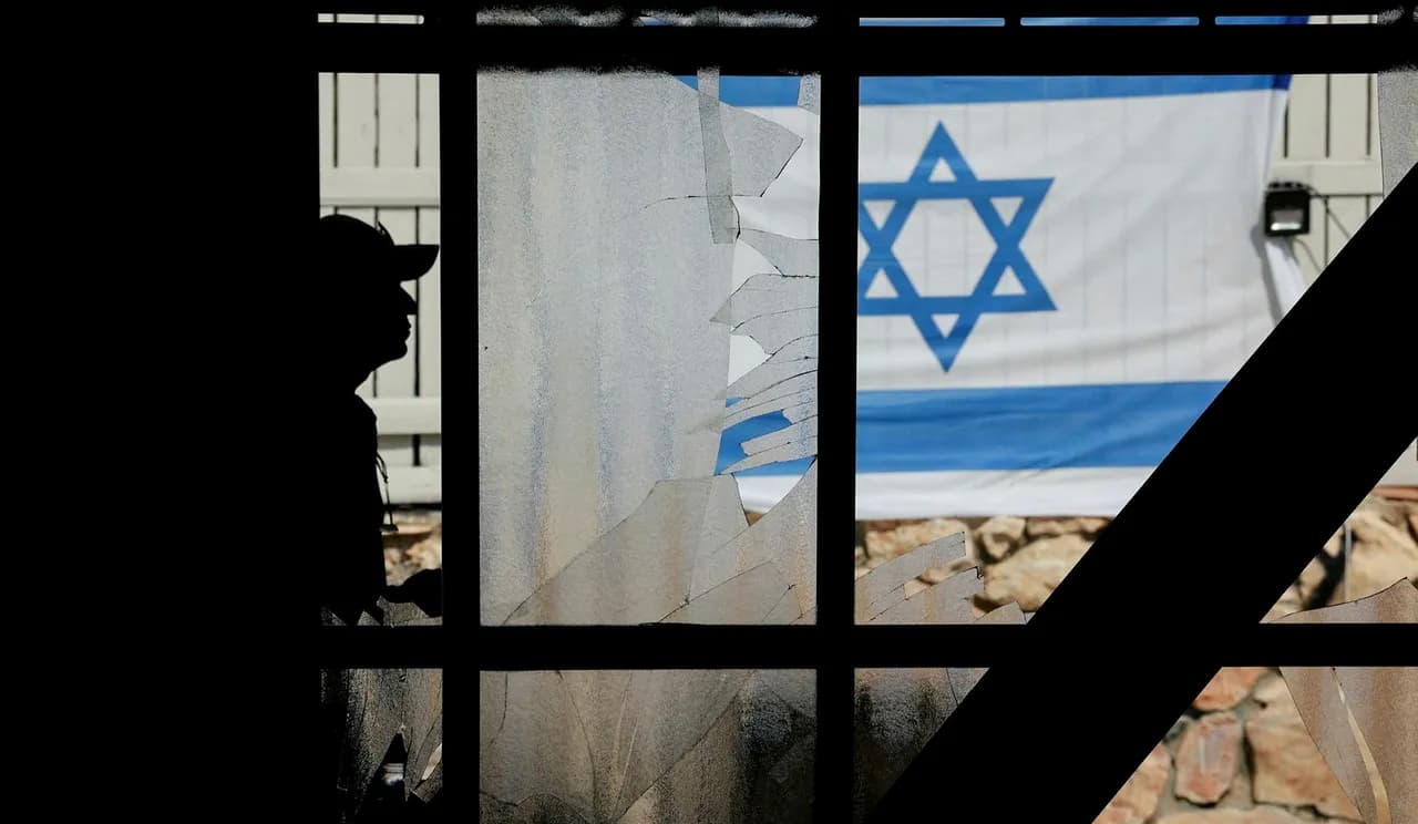 Israeli flag and man seen through damaged window