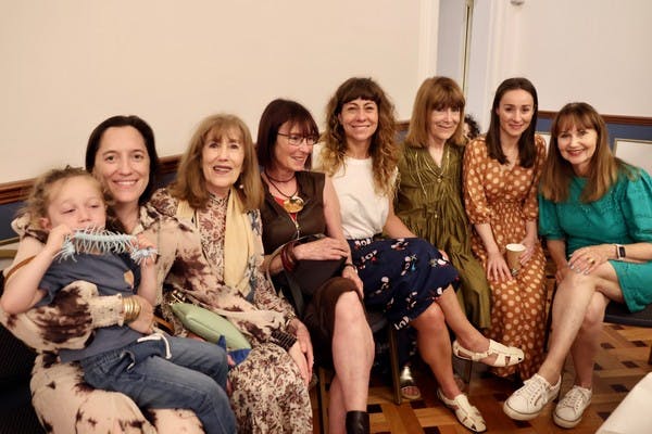 A group of women sitting together smiling