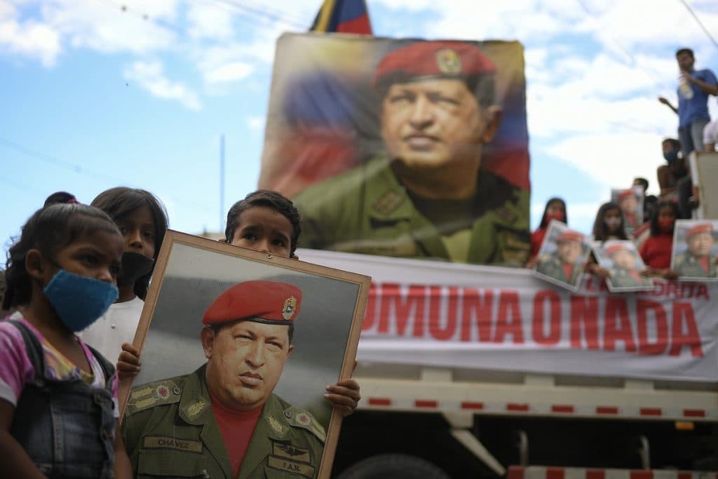 Children hold a portrait of Hugo Chavez in Caracas, Februry 2021 (AP/Matias Delacroix)