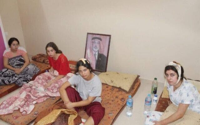 An undated picture of four IDF surveillance soldiers held hostage by Hamas in Gaza since October 7, 2023, that was made public by their families on July 16, 2024. Behind them is a framed picture of Hamas leader Ismail Haniyeh. From left: Liri Albag, Agam Berger, Daniella Gilboa, and Karina Ariev (Courtesy)